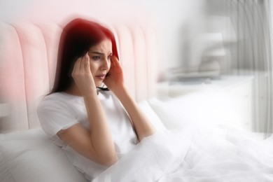 Image of Young woman suffering from migraine in bed at home