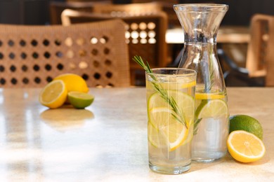 Photo of Summer refreshing lemonade on light table in cafe, space for text