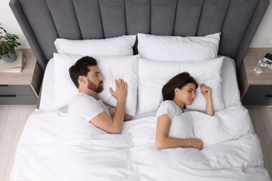 Photo of Lovely couple sleeping together in bed at home, top view