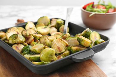 Photo of Delicious roasted brussels sprouts in baking dish, closeup