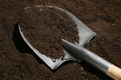 Photo of Metal shovel on fertile soil. Gardening tool