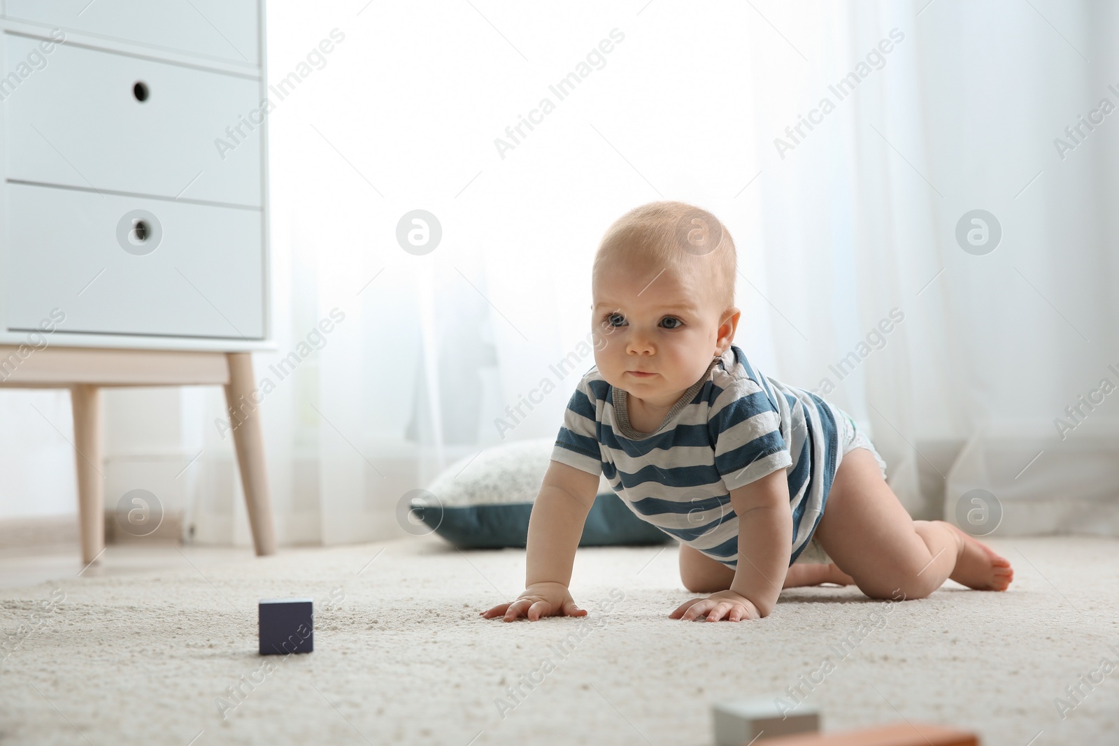 Photo of Cute little baby crawling on carpet indoors