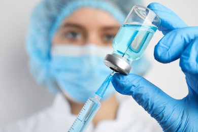 Photo of Doctor filling syringe with medication, closeup. Vaccination and immunization