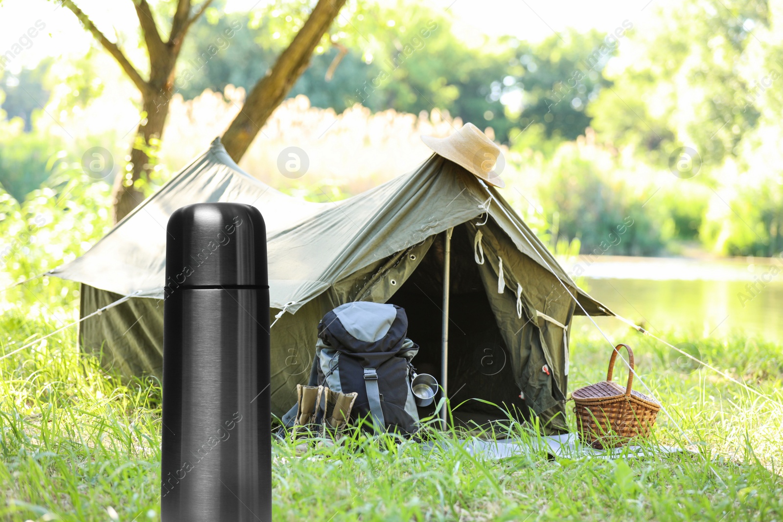 Image of Modern thermos outdoors, space for text. Camping season 