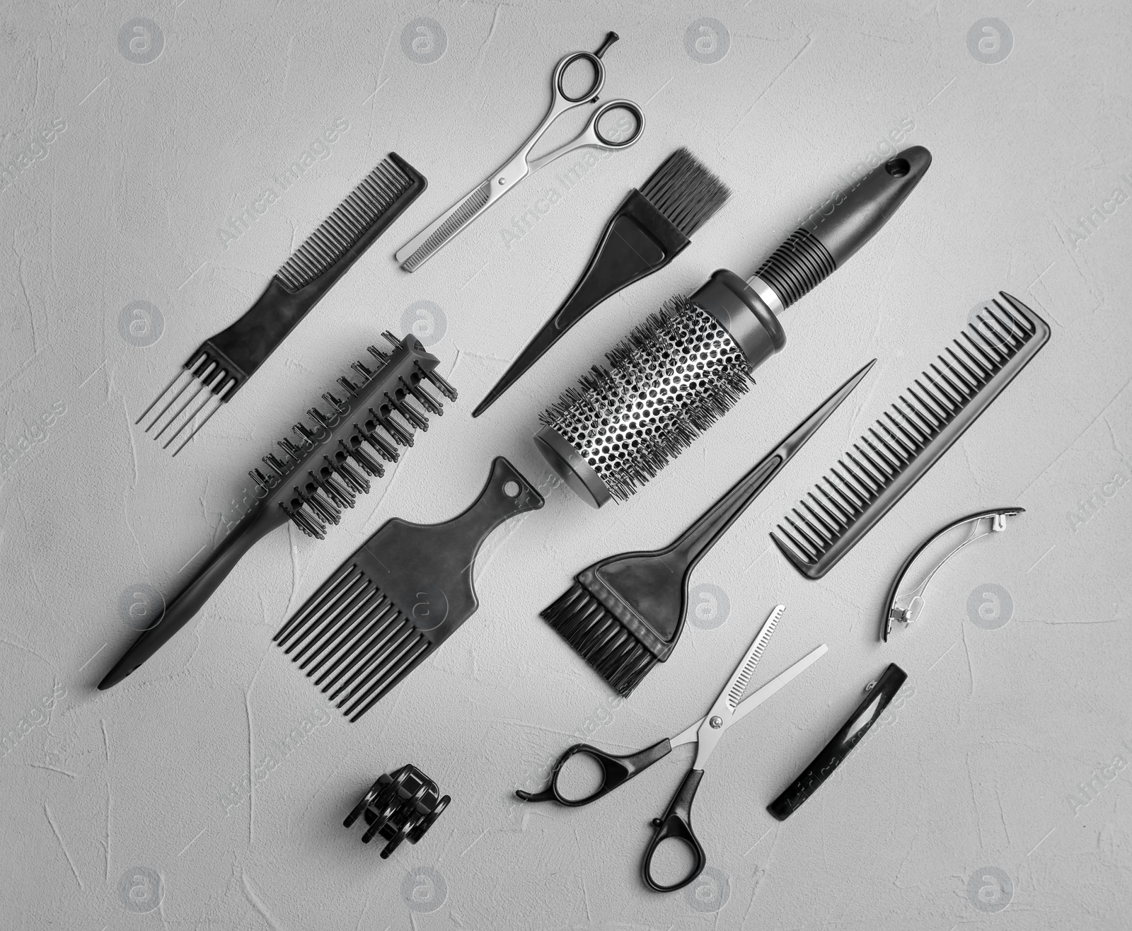 Photo of Flat lay composition with professional hairdresser tools on grey background