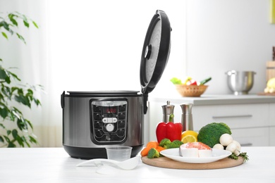 Modern multi cooker and products on kitchen table