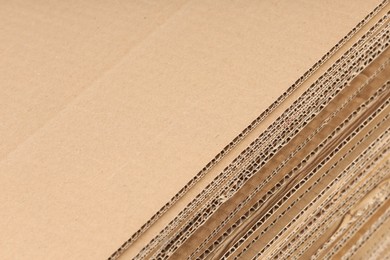 Photo of Sheets of brown corrugated cardboard as background, closeup