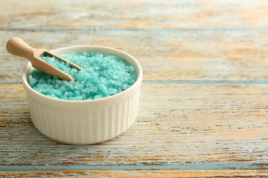 Bowl and scoop with turquoise sea salt on rustic table, space for text