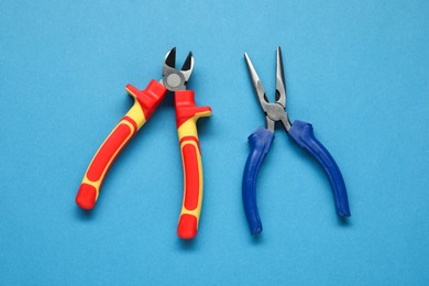 Photo of Pliers on light blue background, flat lay