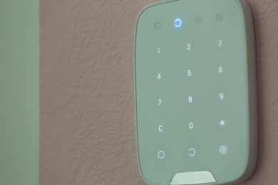Photo of Alarm system keypad hanging on wall indoors