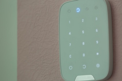 Alarm system keypad hanging on wall indoors