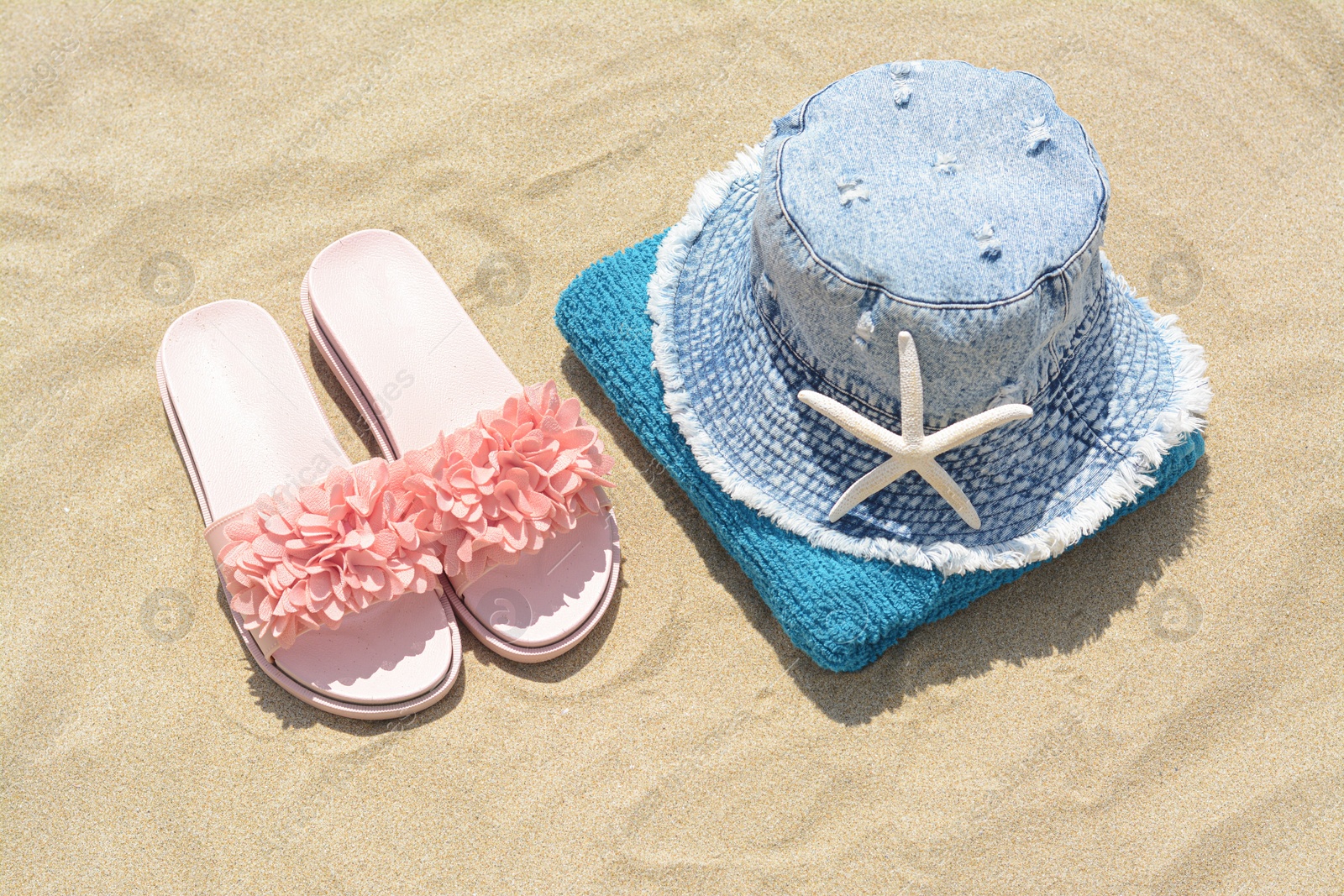 Photo of Stylish beach accessories on sand outdoors, above view