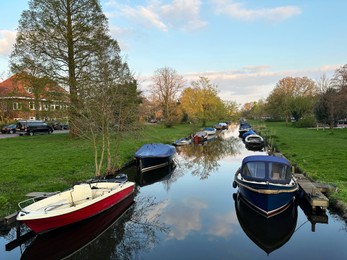 Photo of Beautiful view of canal with moored boats under blue sky