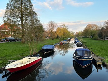 Beautiful view of canal with moored boats under blue sky