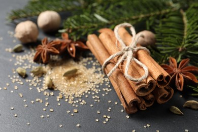 Photo of Cinnamon sticks and other spices on gray table, closeup