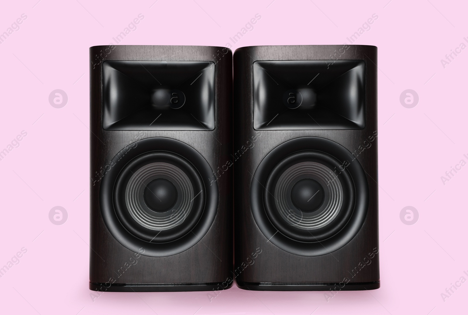 Photo of Modern wooden sound speakers on pink background