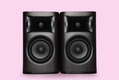 Photo of Modern wooden sound speakers on pink background