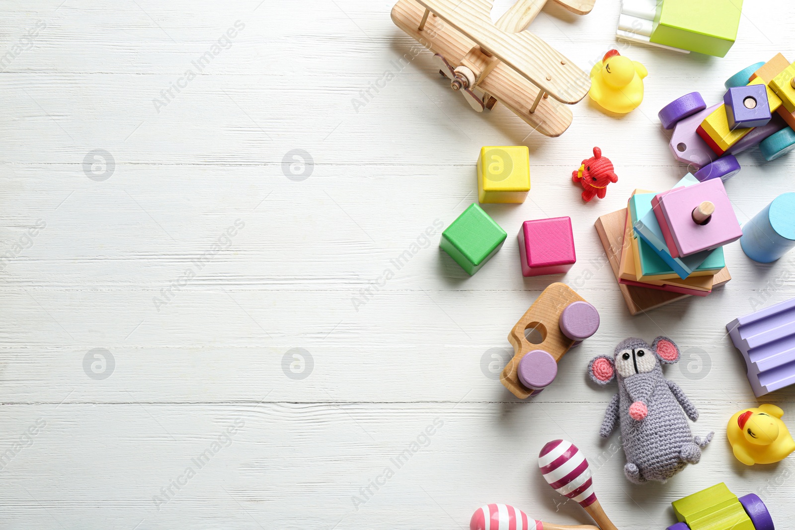 Photo of Different toys on white wooden background, flat lay. Space for text