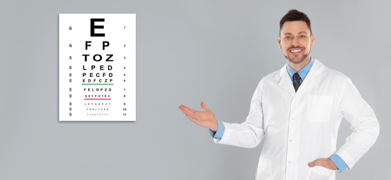Vision test. Ophthalmologist or optometrist pointing at eye chart on light grey background, banner design