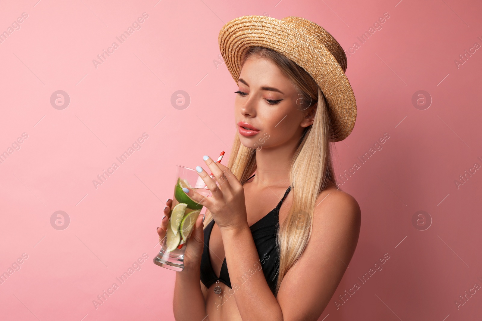 Photo of Pretty young woman wearing stylish bikini with cocktail on pink background