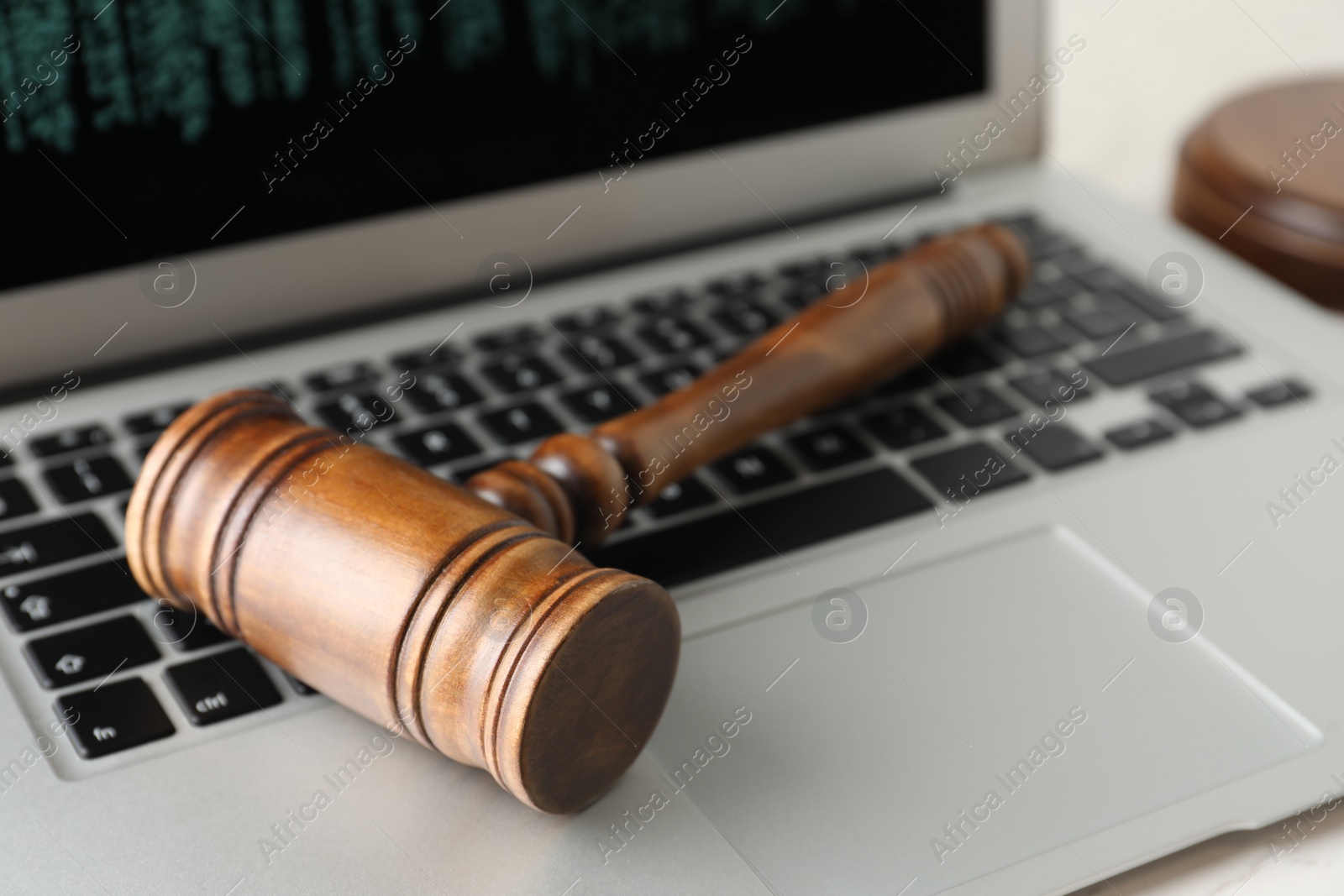 Photo of Modern laptop and wooden gavel on table, closeup. Cyber crime