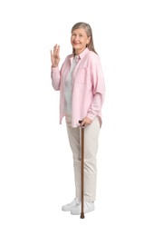 Senior woman with walking cane waving on white background