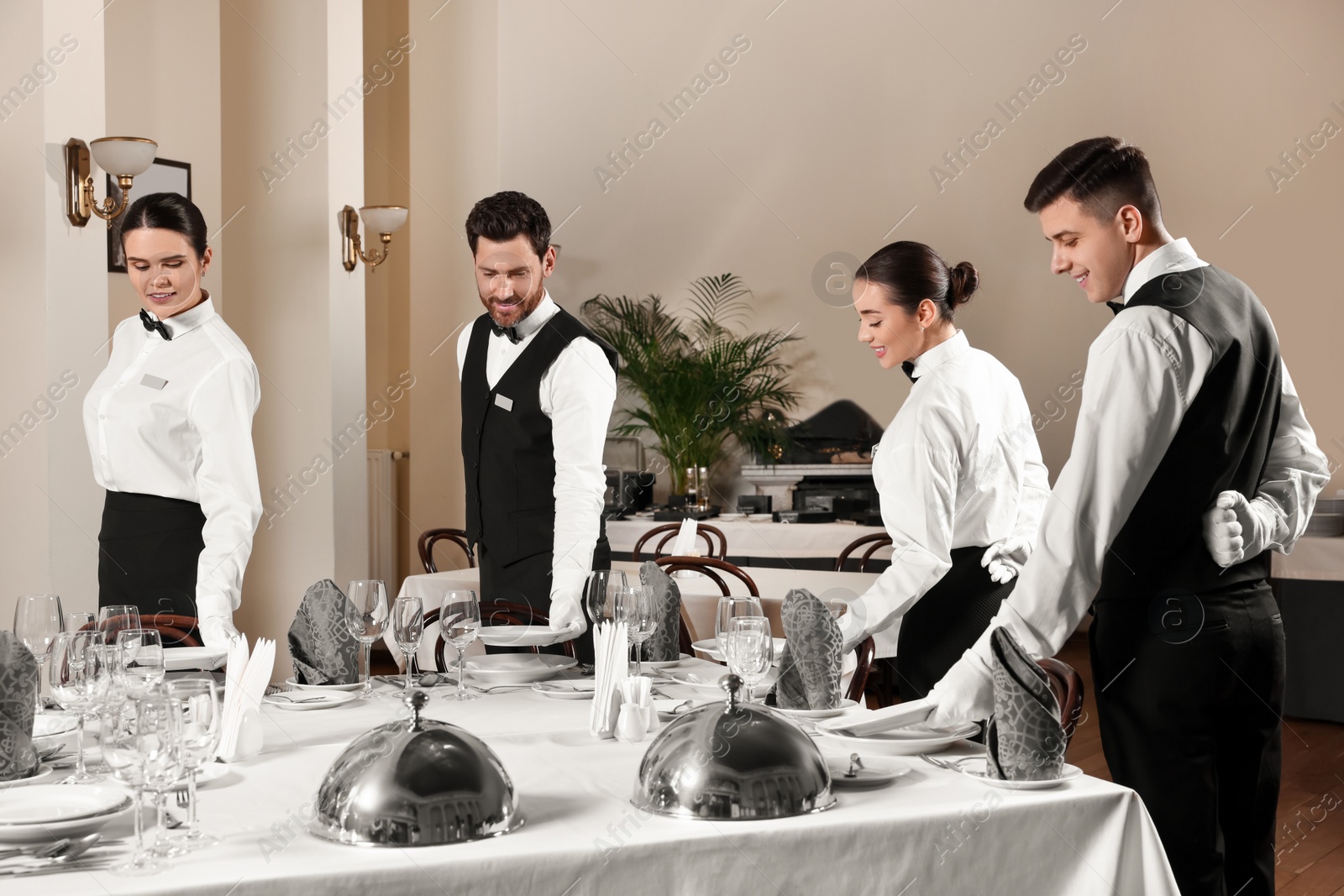 Photo of People setting table during professional butler courses in restaurant