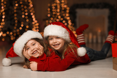 Cute little children wearing Santa hats at home. Christmas time