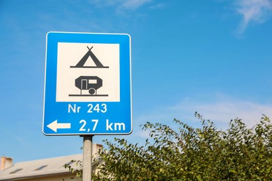 Road sign Camping Site Equipped With Power Sockets For Trailers against blue sky outdoors