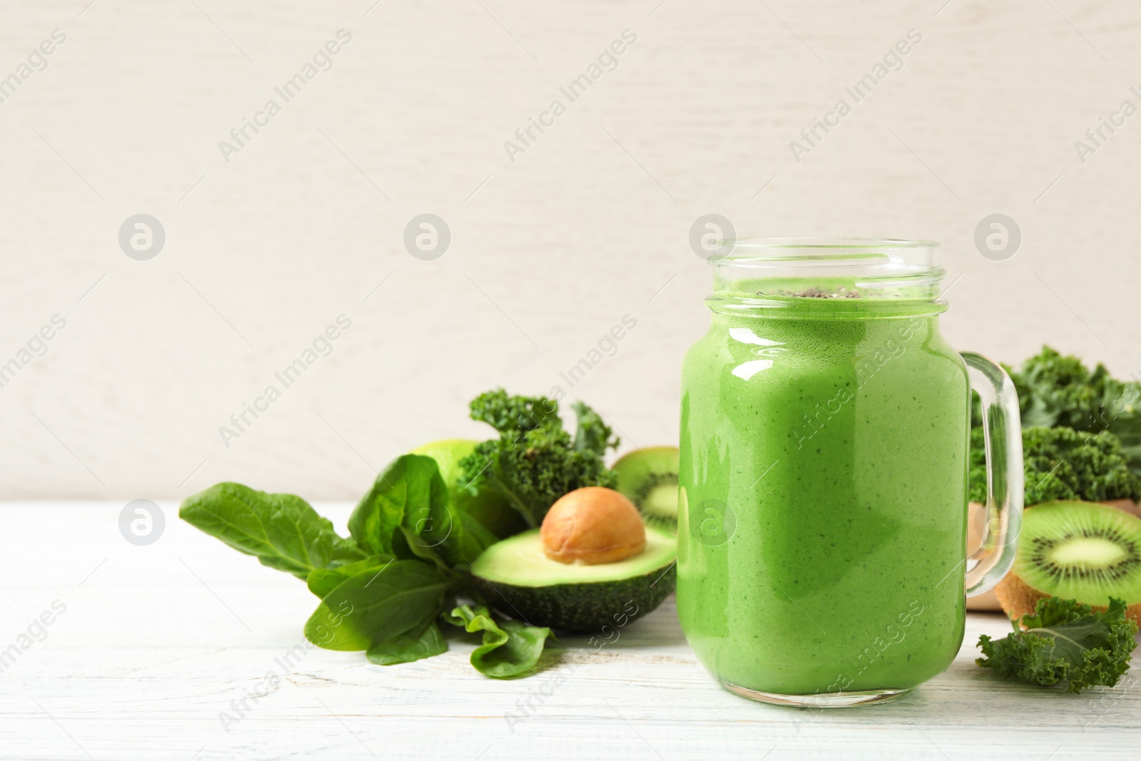 Photo of Tasty fresh kale smoothie on white wooden table