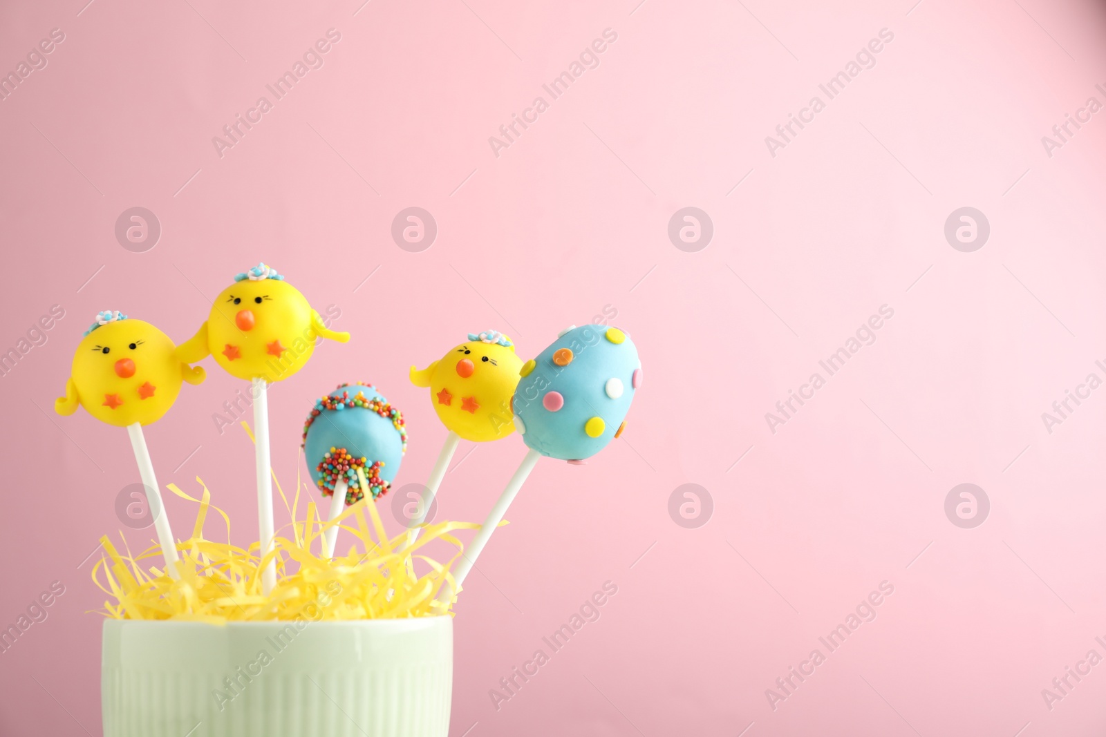 Photo of Delicious sweet cake pops on light pink background, space for text. Easter holiday