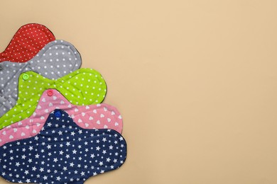 Photo of Many reusable cloth menstrual pads on beige background, flat lay. Space for text