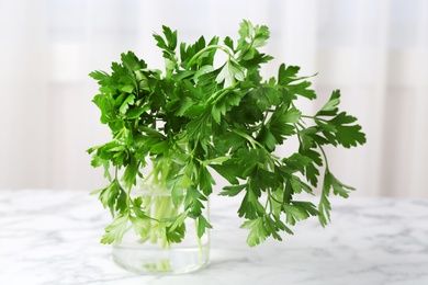 Jar with fresh green parsley on table