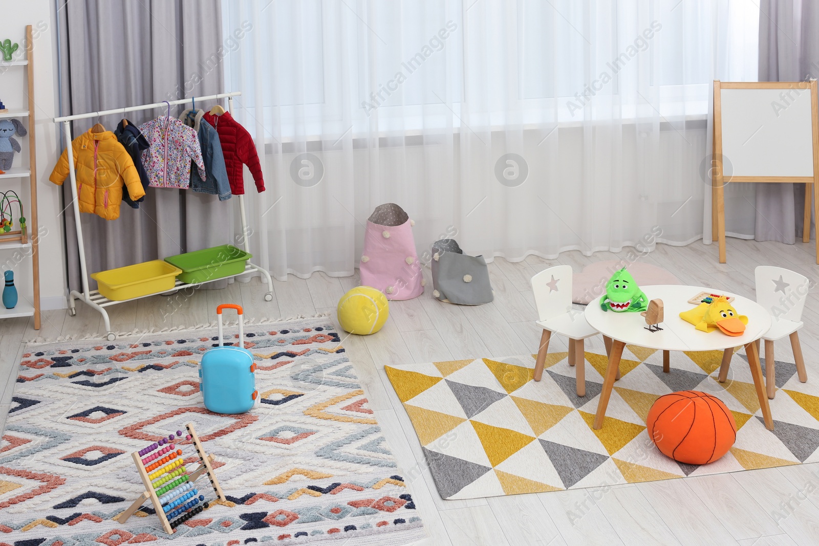 Photo of Child`s playroom with different toys and modern furniture. Stylish kindergarten interior