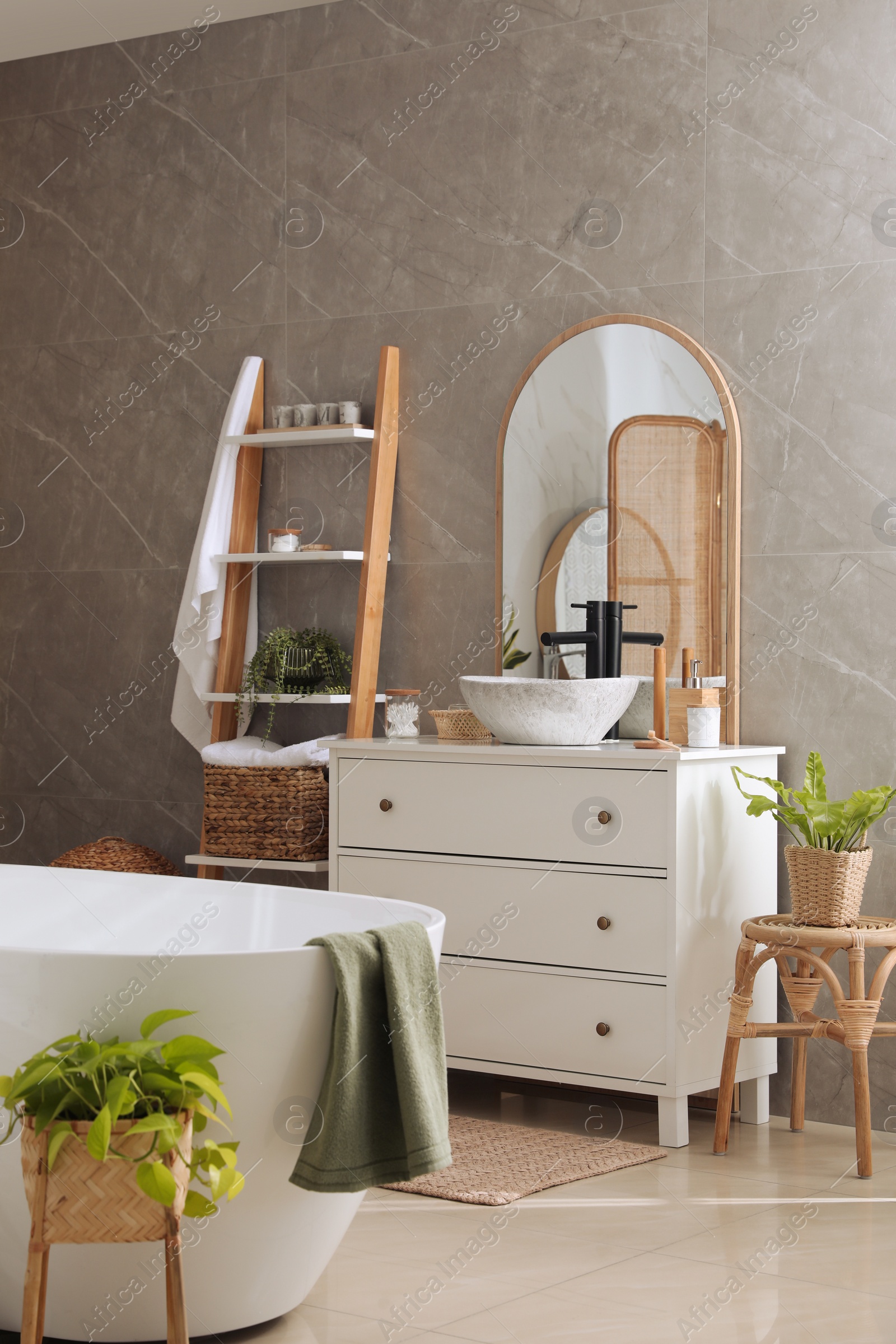 Photo of Modern white tub and chest of drawers with sink in bathroom. Interior design