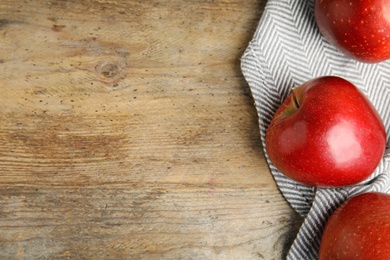 Photo of Ripe juicy red apples on wooden background, flat lay. Space for text