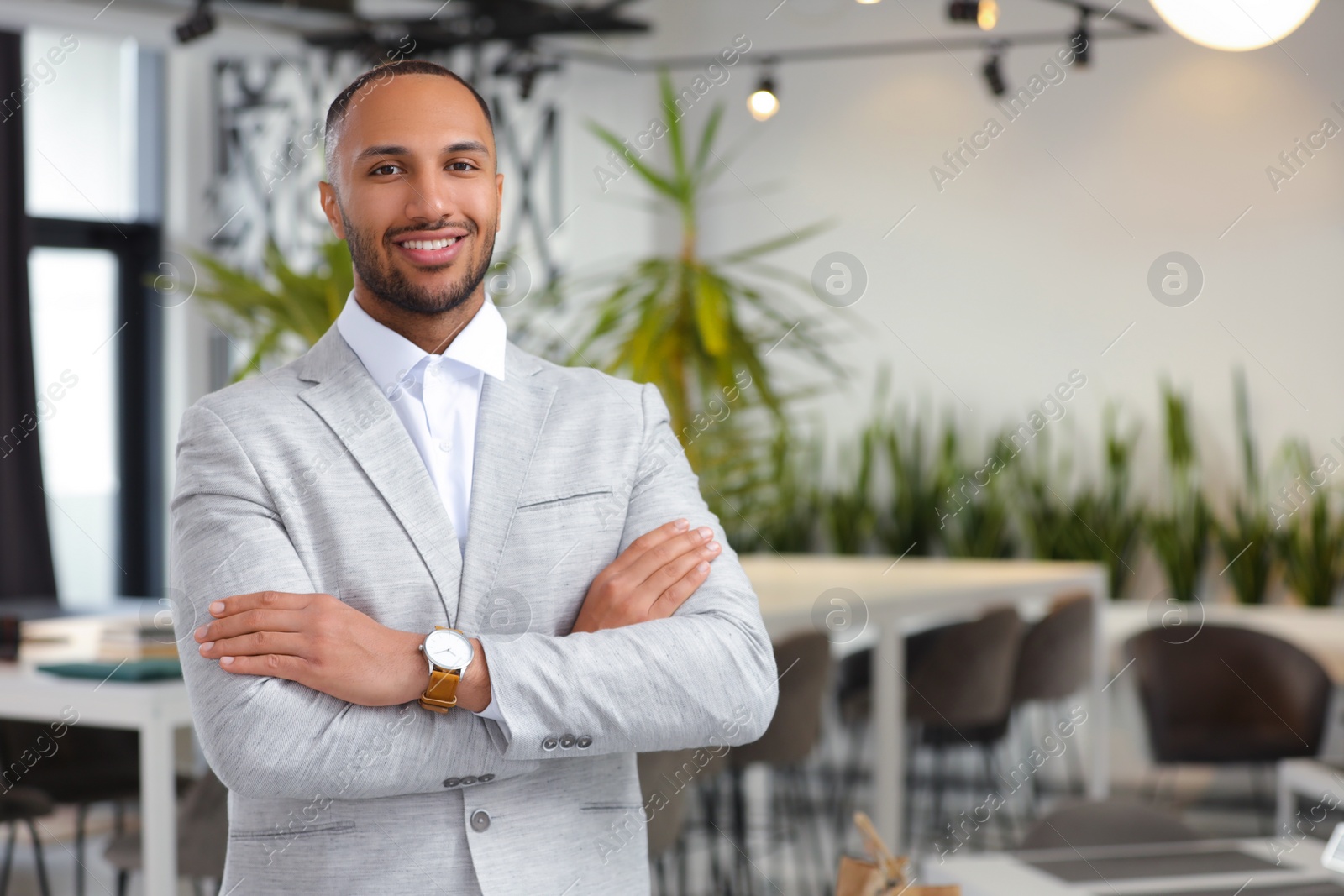 Photo of Happy man with crossed arms in office, space for text. Lawyer, businessman, accountant or manager