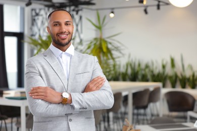 Photo of Happy man with crossed arms in office, space for text. Lawyer, businessman, accountant or manager