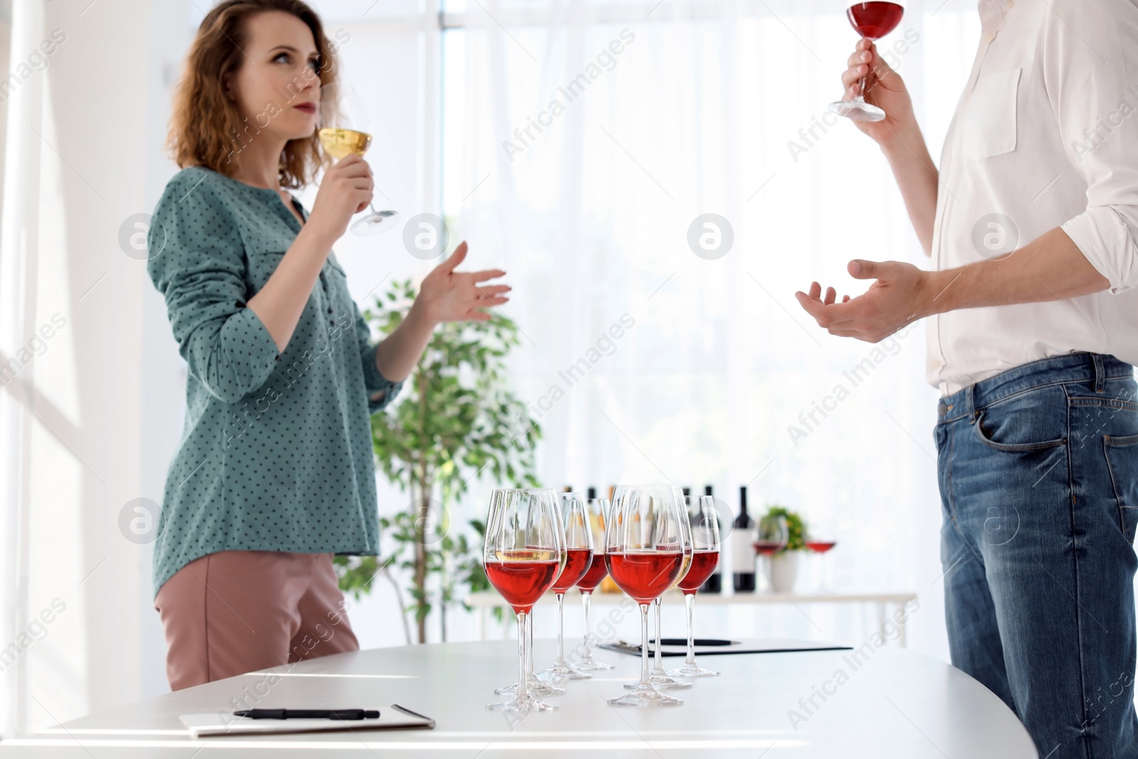 Photo of Young couple tasting wine at table indoors