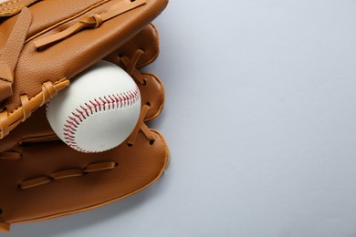Photo of Catcher's mitt and baseball ball on white background, top view with space for text. Sports game