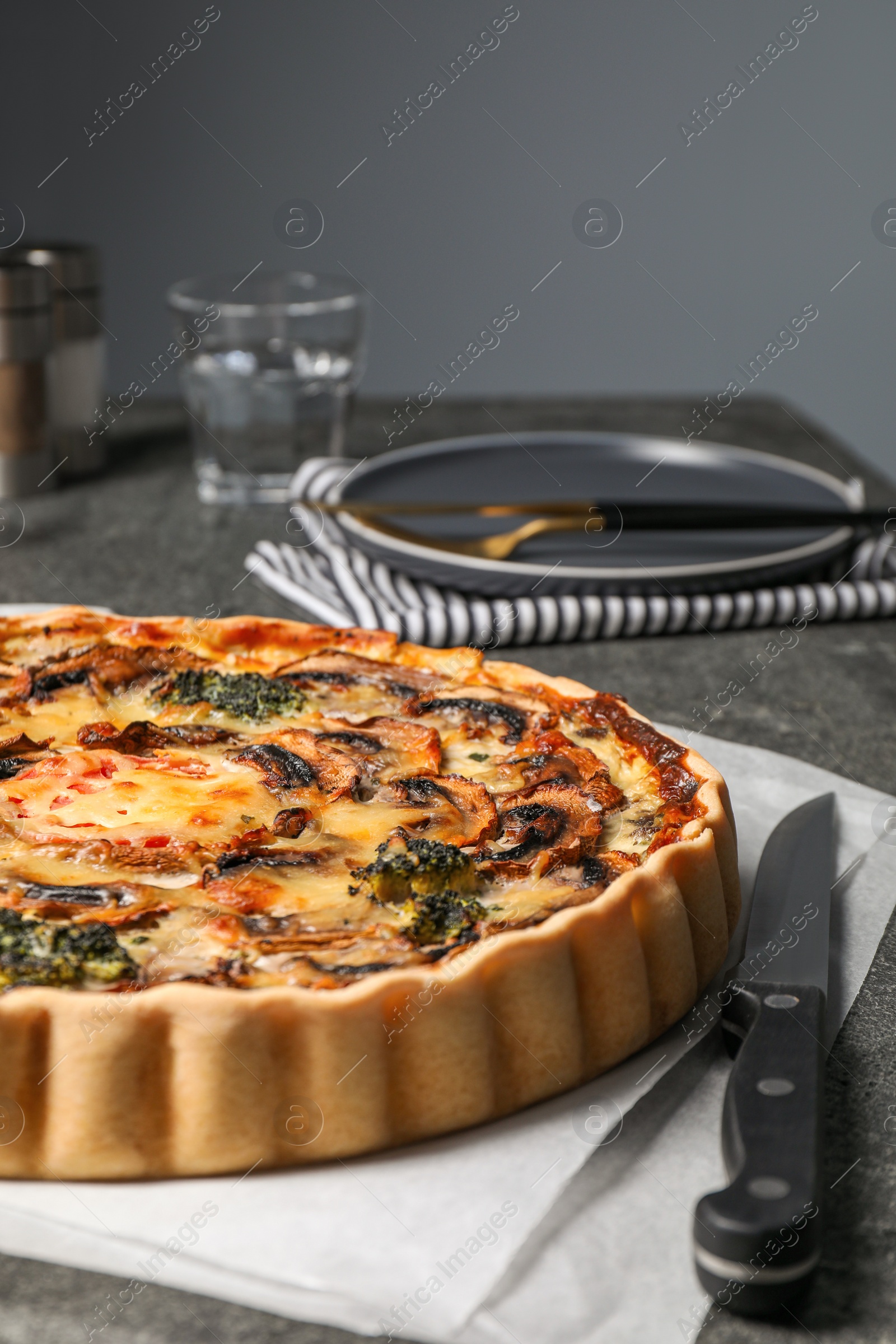 Photo of Delicious quiche with mushrooms and knife on table, closeup