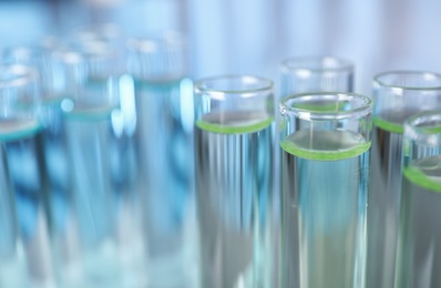 Test tubes with liquid on blurred background, space for text. Laboratory analysis