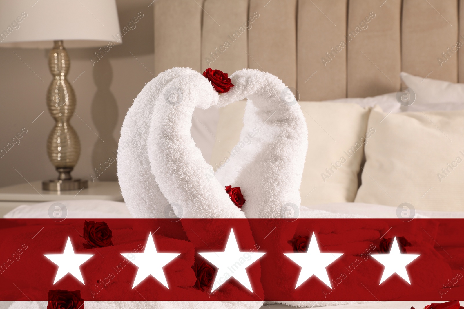 Image of Five Star Luxury Hotel. Beautiful swans made of towels decorated with red roses on bed in five star hotel room