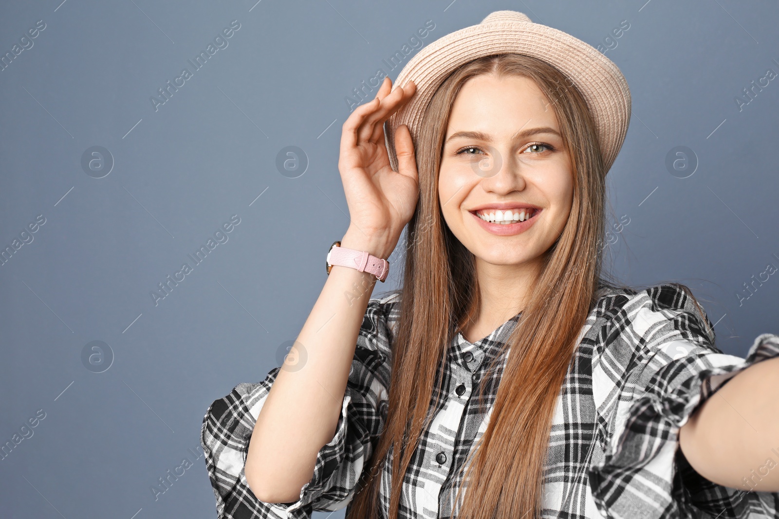 Photo of Young beautiful woman taking selfie against grey background