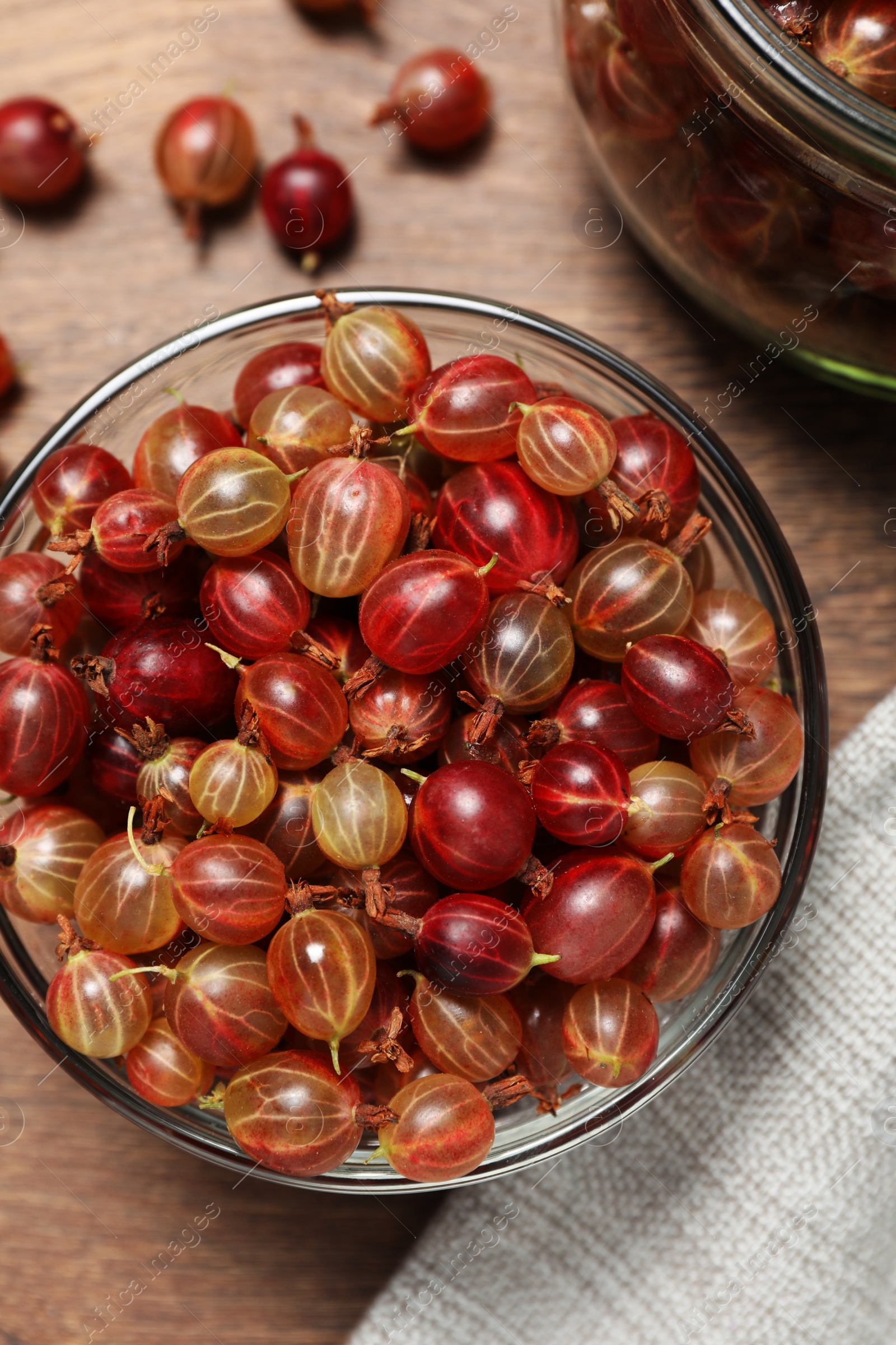 Photo of Many fresh ripe gooseberries on wooden table, flat lay