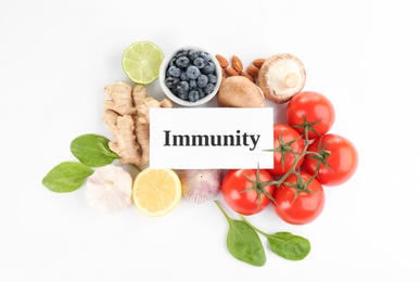 Photo of Set of natural products and card with word Immunity on white background, top view