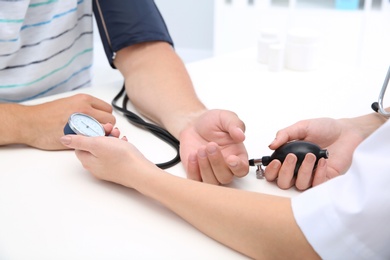 Photo of Doctor checking young man's pulse in hospital