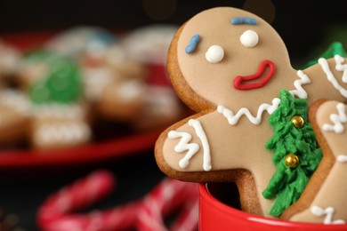 Delicious homemade Christmas cookies in cup against blurred background, closeup. Space for text