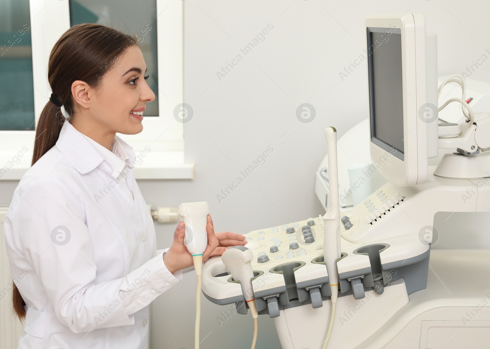 Photo of Professional sonographer using modern ultrasound machine in clinic