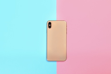 Photo of Modern smartphone on colorful background, top view